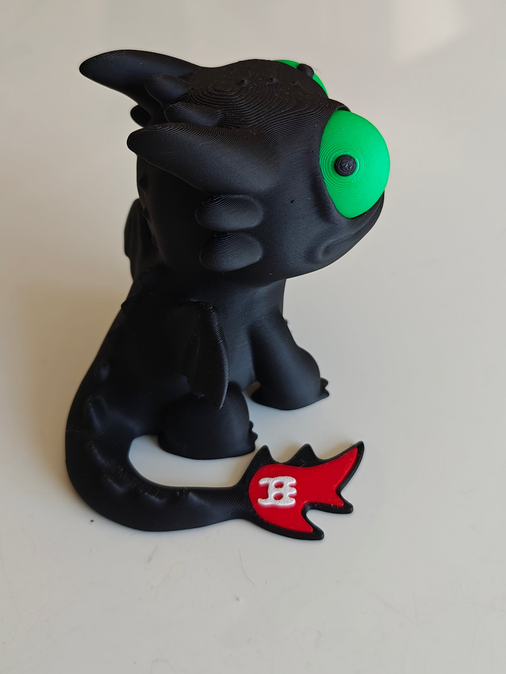 Toothless dragon figure with big movable googly eyes, front view on white background