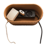 Cable box positioned under desk with power cord and charging cables routed through side openings