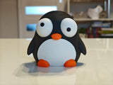 Goofy penguin figure with movable eyes, close-up on white background