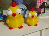 Close-up of goofy chicken figure with large movable googly eyes on white background