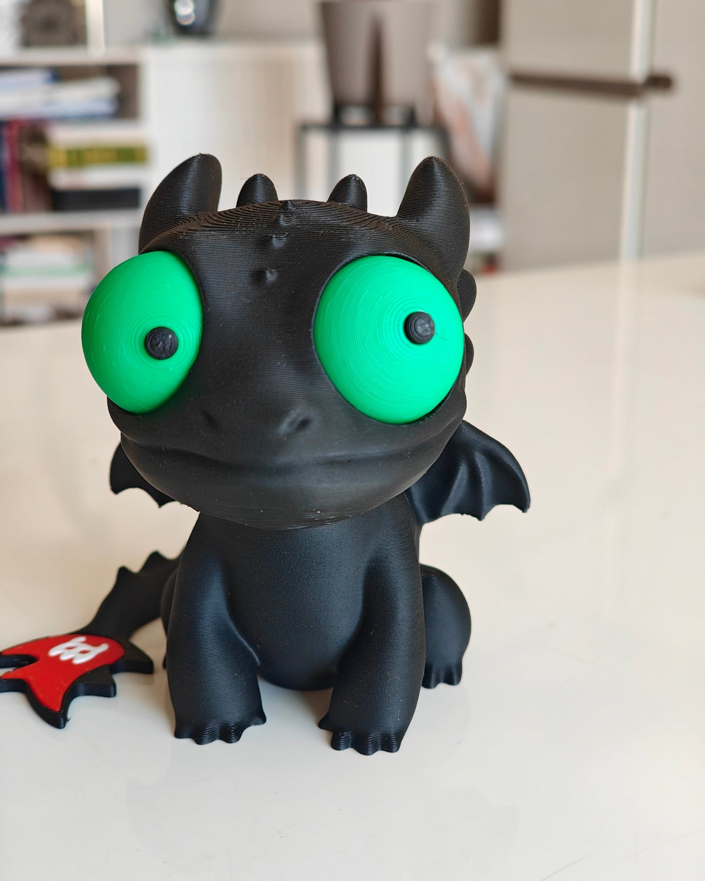 Toothless dragon figure with big movable googly eyes, front view on white background