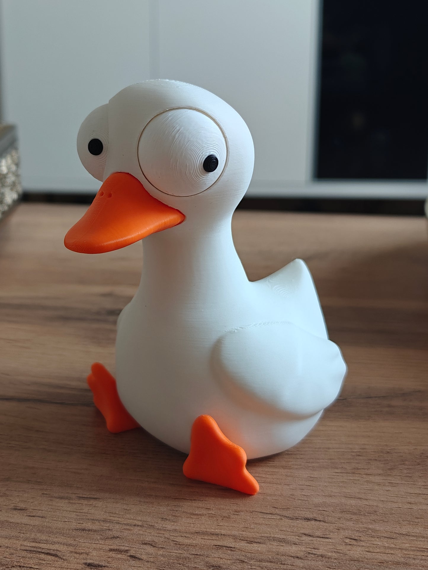 Goofy goose figure with large movable googly eyes on a white background
