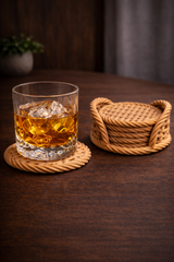 Set of five beige woven coasters with matching cylindrical holder displayed together