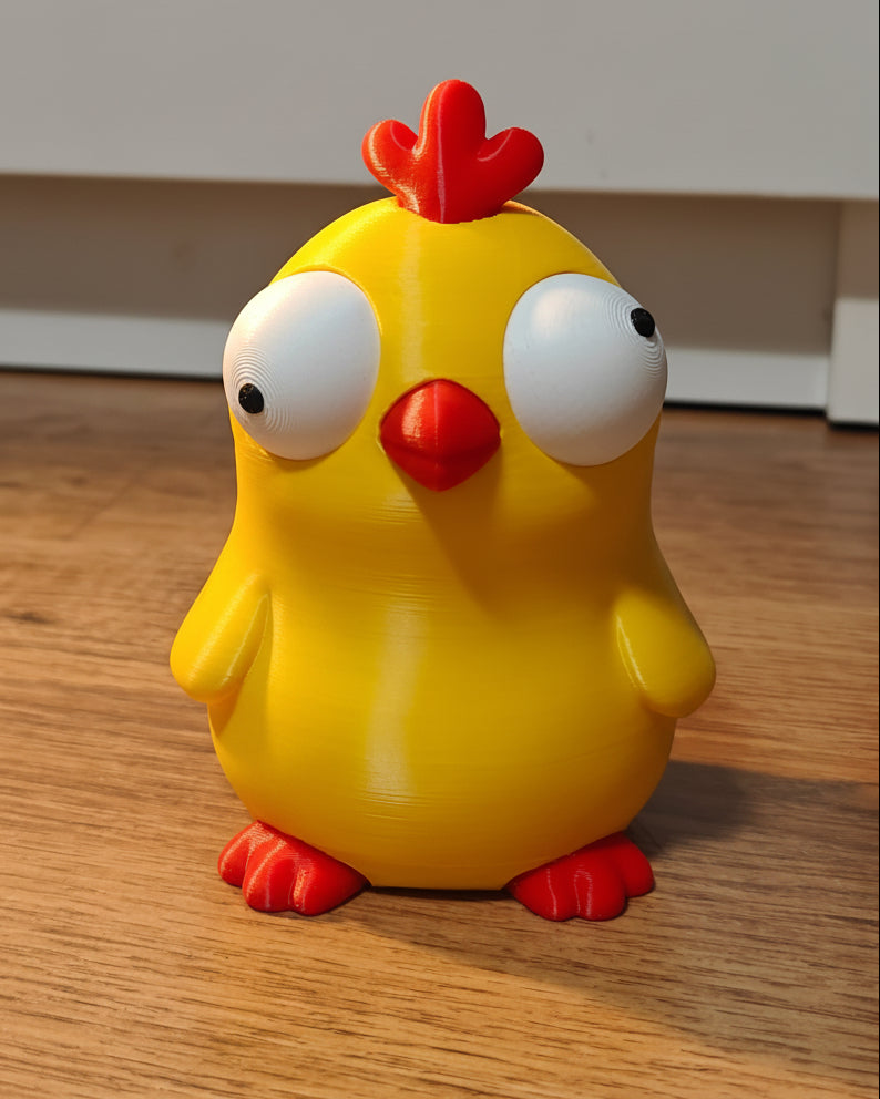 Close-up of goofy chicken figure with large movable googly eyes on white background
