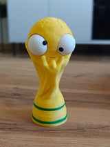 Close-up of goofy world cup trophy figure with large movable googly eye, front view