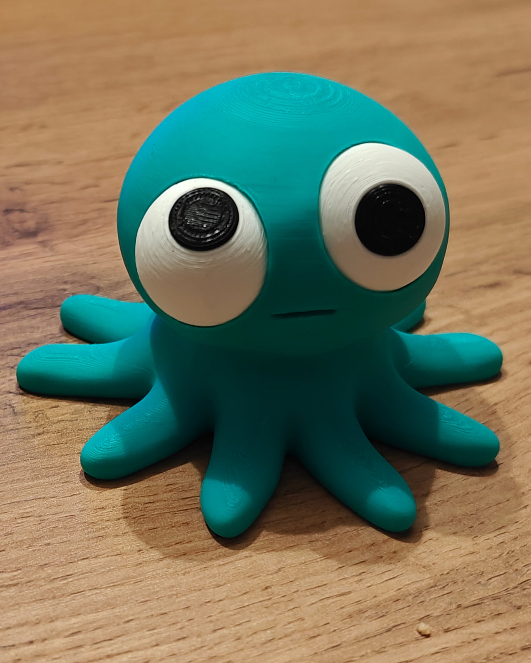 Goofy octopus figure with movable googly eyes, close-up on white background