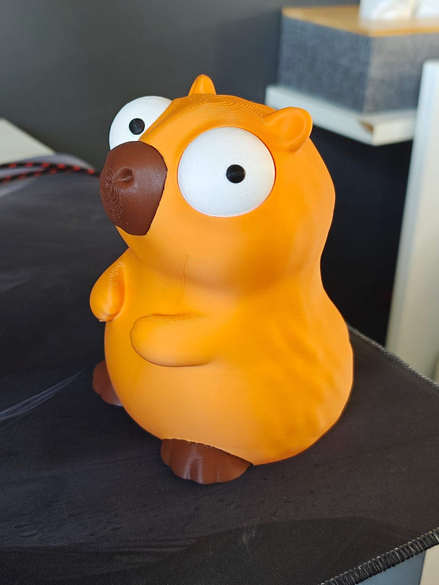 Capybara figure with big movable googly eyes, front view on white background