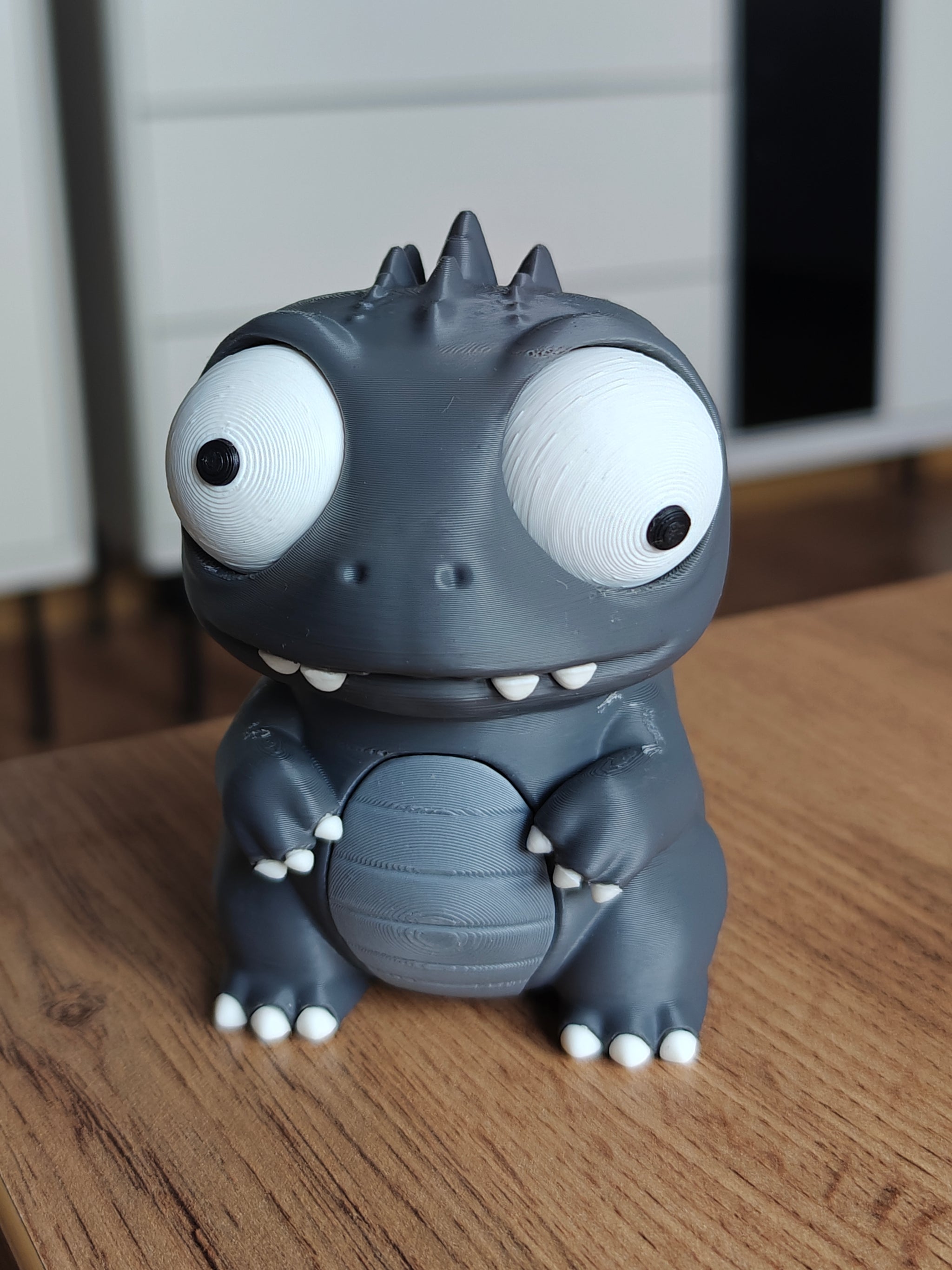 Kaiju dino monster figure with large movable googly eyes, front view on white background