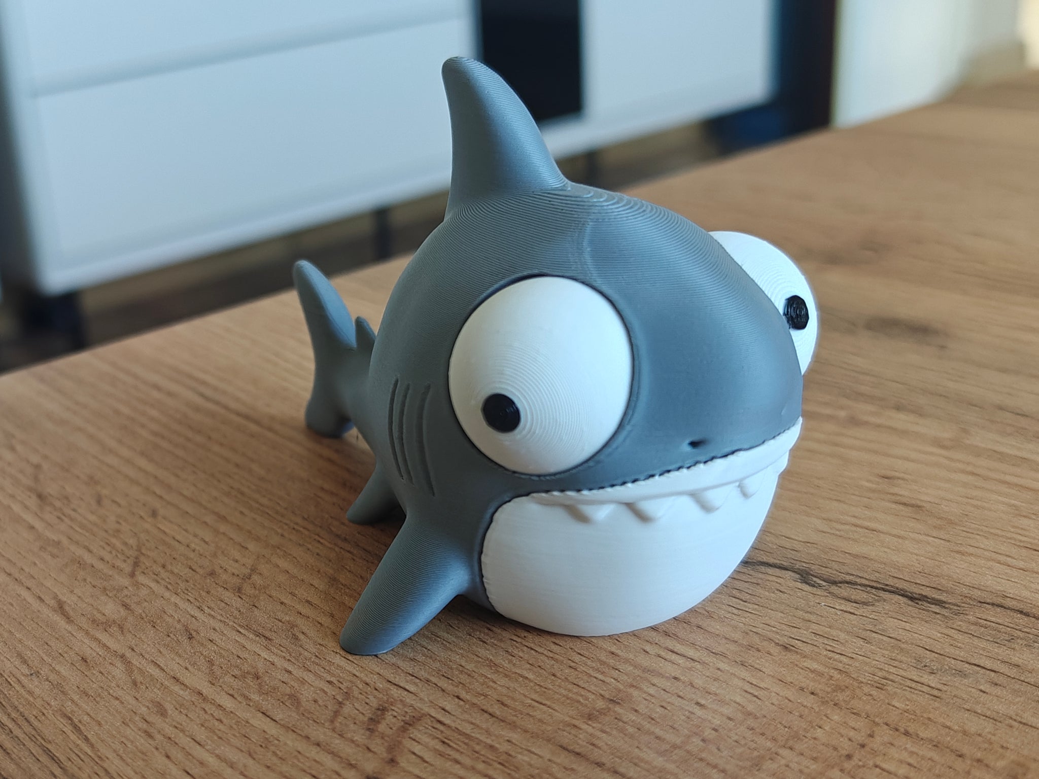 Goofy shark figure with large movable googly eyes on a white background