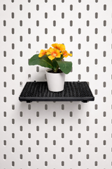 Modular white pegboard shelf designed for IKEA Skadis system, displaying plants and decorative items