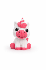 Unicorn figure displayed on wooden shelf next to books and decorative items