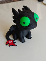 Toothless dragon figure with big movable googly eyes, front view on white background
