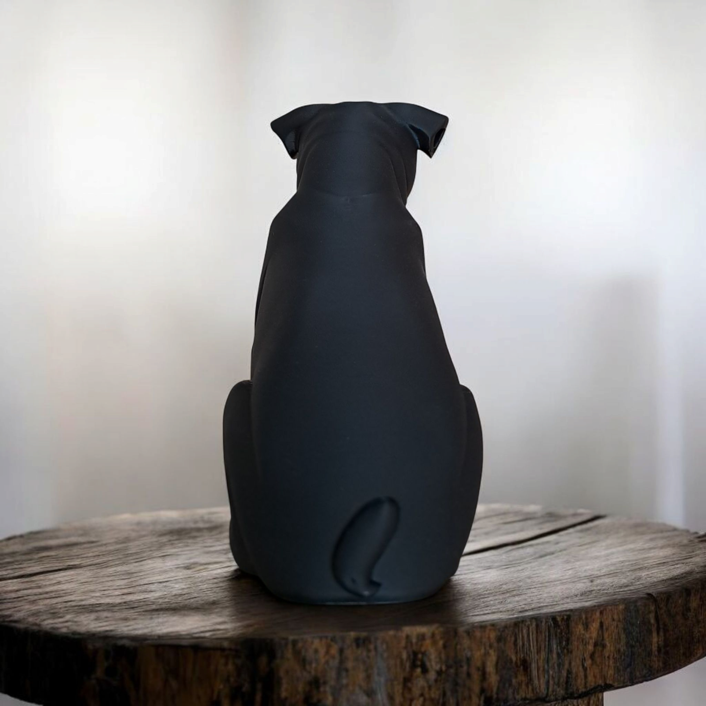 Close-up of minimalist pug sculpture showing smooth matte black surface