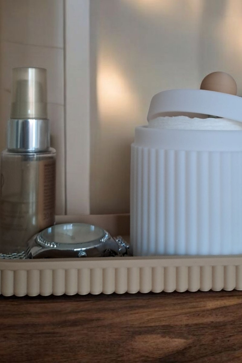 Close-up of ribbed jewelry organizer jar with lid and matching tray in pink and white
