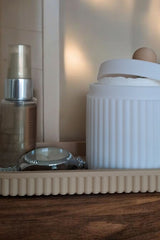 Close-up of ribbed jewelry organizer jar with lid and matching tray in pink and white
