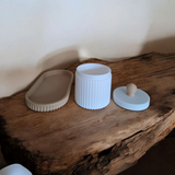 Close-up of ribbed jewelry organizer jar with lid and matching tray in pink and white