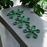 Three plant support hooks installed in potted plants on a bright windowsill