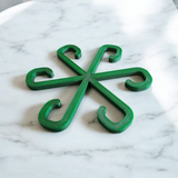 Close-up of minimalist plant support hook in neutral finish against white background