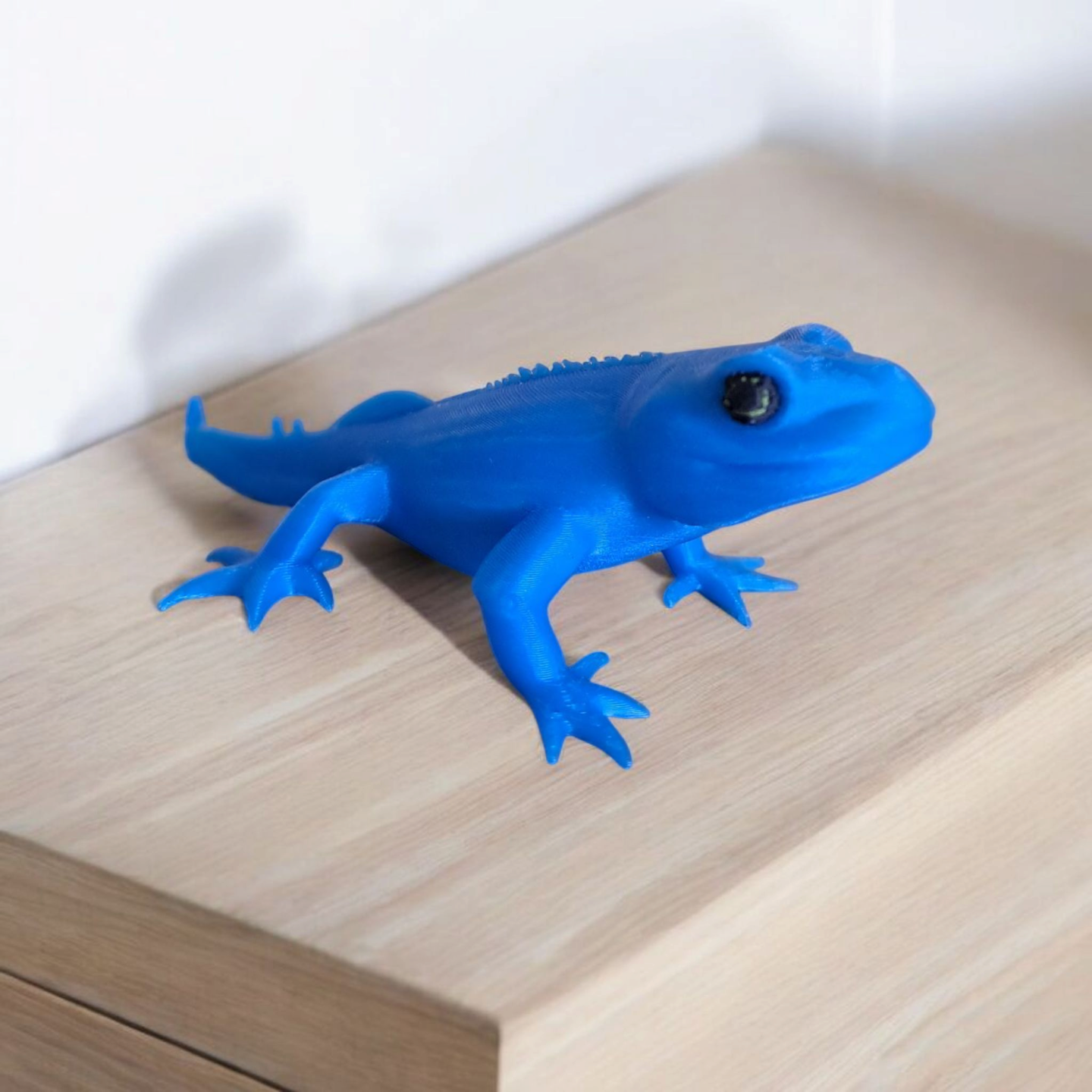 Close-up of a cute gecko figurine with detailed features and playful proportions
