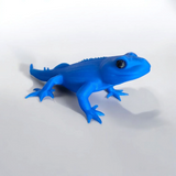 Close-up of a cute gecko figurine with detailed features and playful proportions