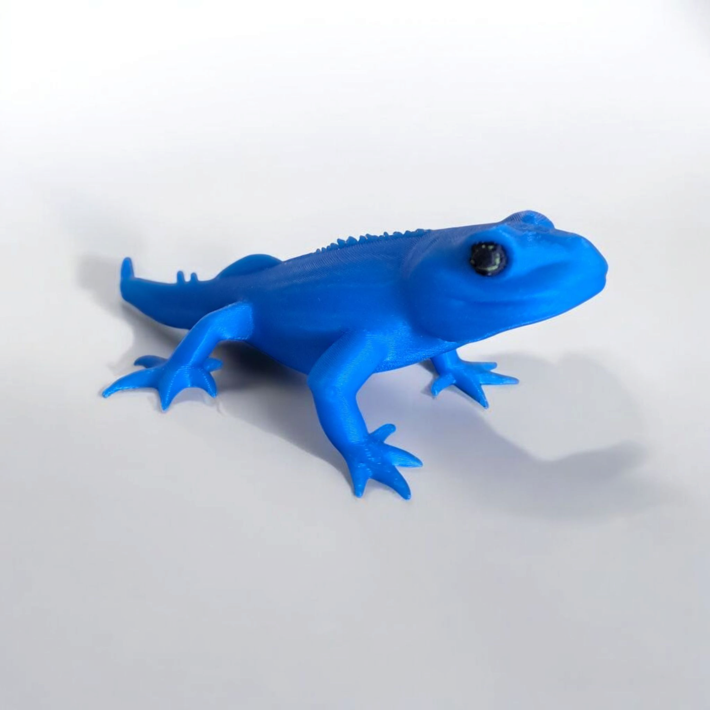 Close-up of a cute gecko figurine with detailed features and playful proportions