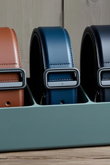 Minimalist belt organizer holding leather belts in neutral tones