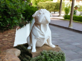 Minimalist pug sculpture displayed on a shelf among books and neutral décor