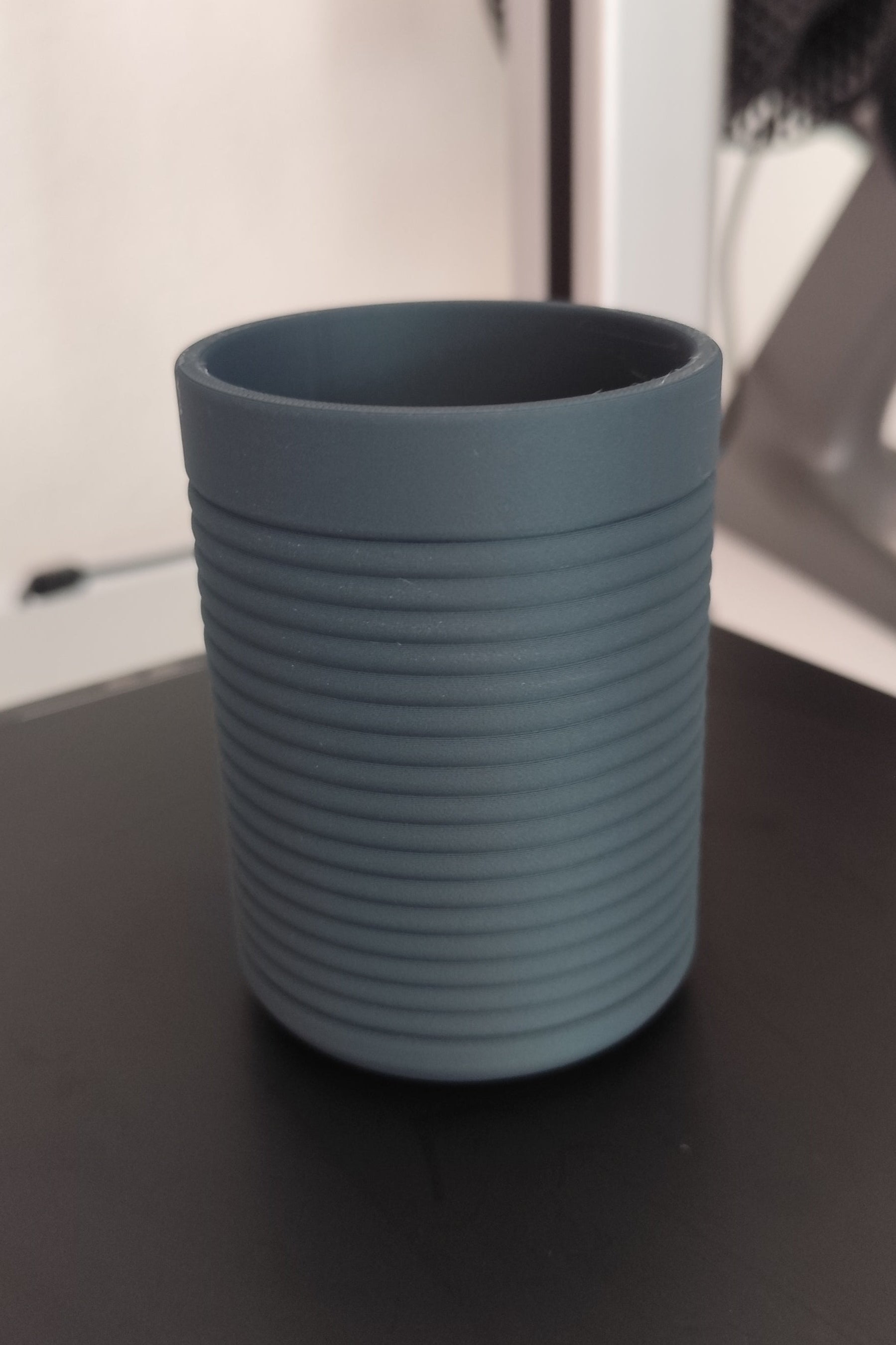 Detail of horizontal ribs catching light on the toothbrush holder surface