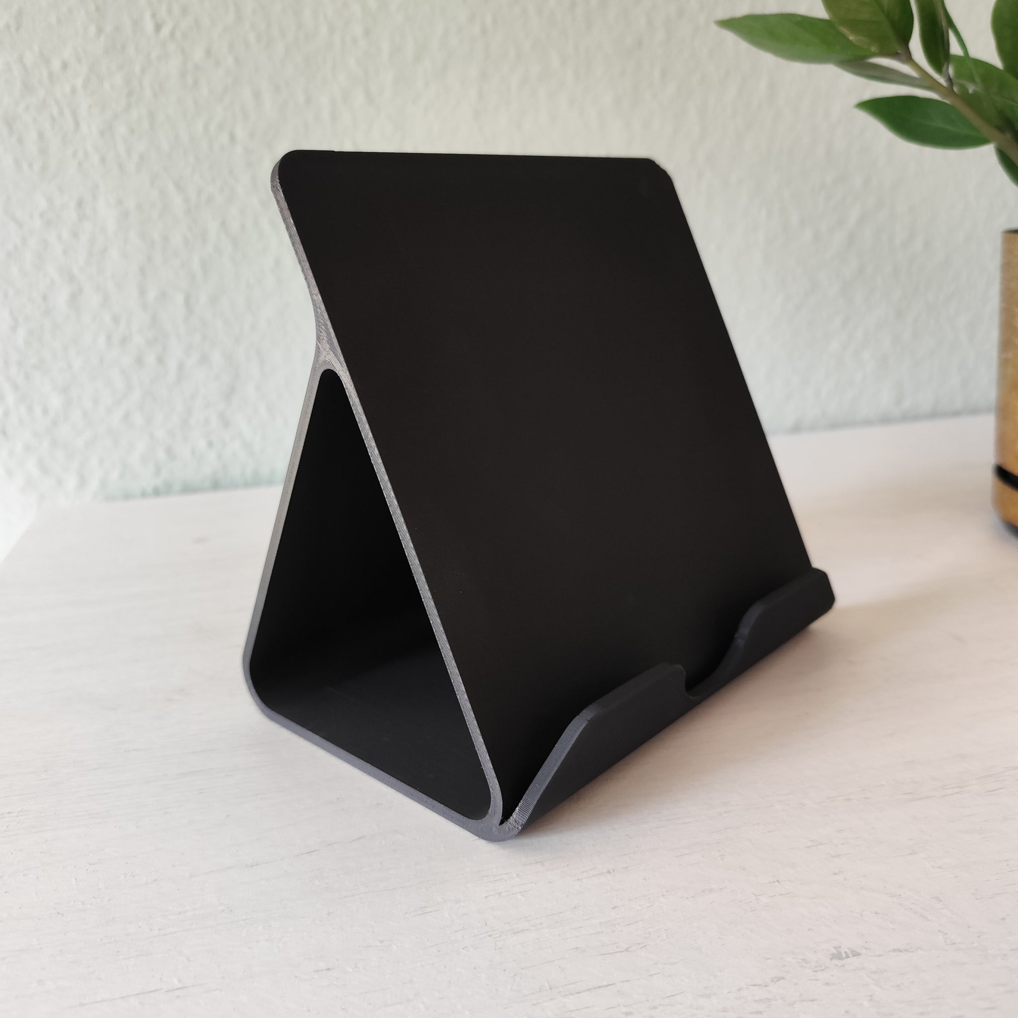 Tablet held in iPad stand on a clean desk next to workspace accessories