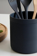 Close-up of ribbed utensil holder with wooden spoon inside, showing vertical texture detail