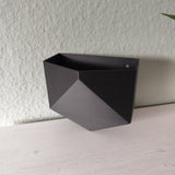 Low poly wall planter mounted on white wall with small potted plant