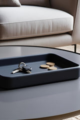 Minimalist rectangular catchall tray in light grey, close-up view showing clean edges