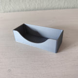 Minimalist business card holder displayed on desk with business cards inserted