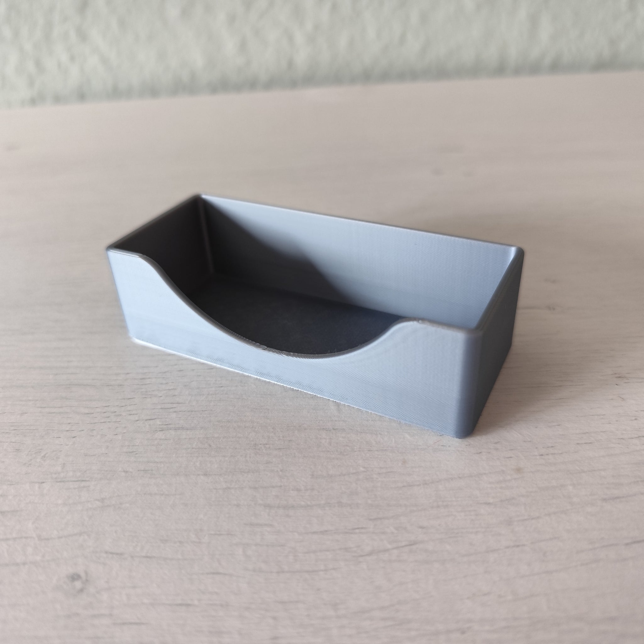 Minimalist business card holder displayed on desk with business cards inserted