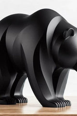 Close-up of minimalist bear sculpture showing curved lines and smooth surface