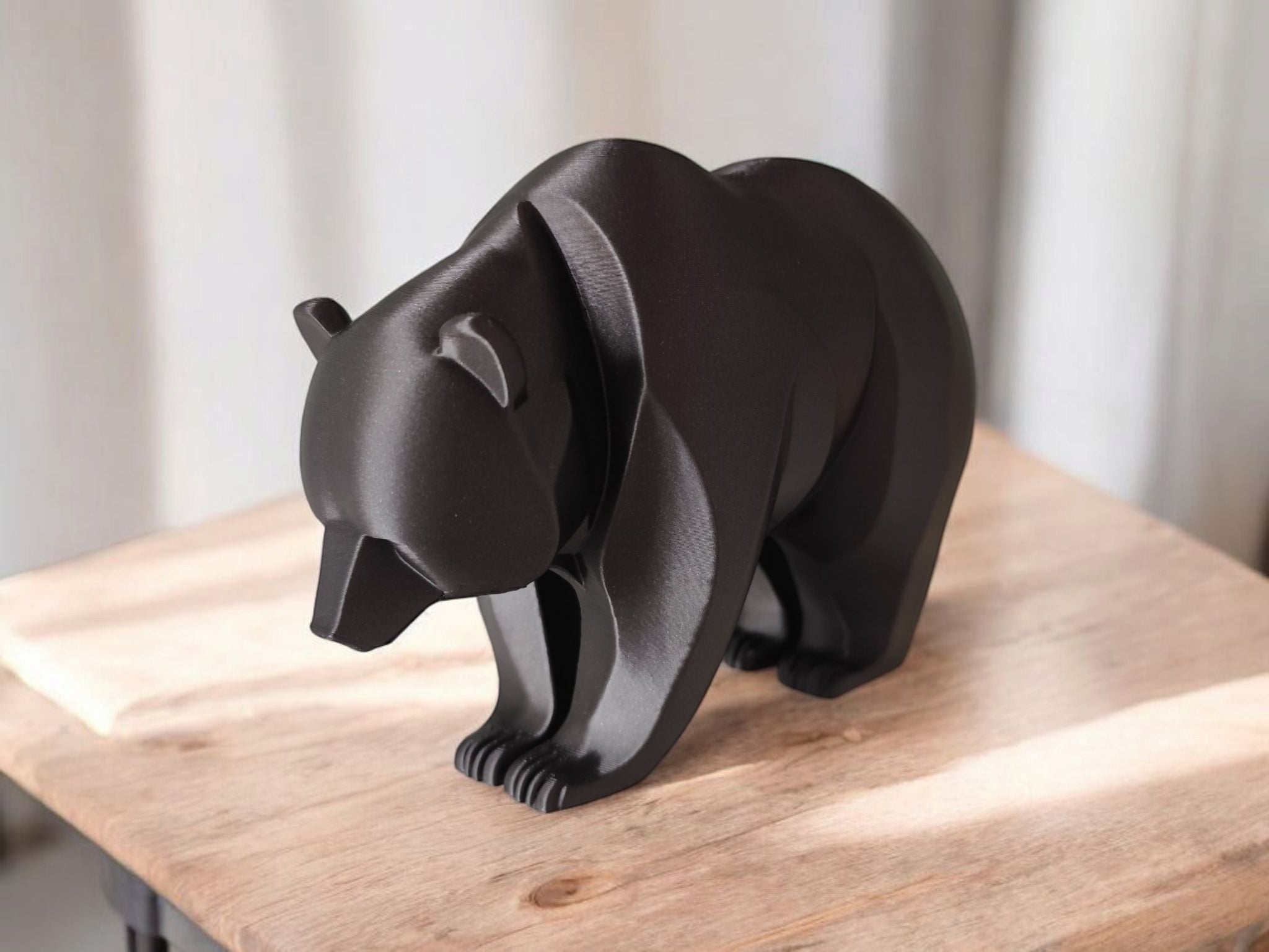 Close-up of minimalist bear sculpture showing curved lines and smooth surface
