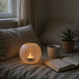 Spherical LED tealight holder in white, close-up showing smooth geometric form