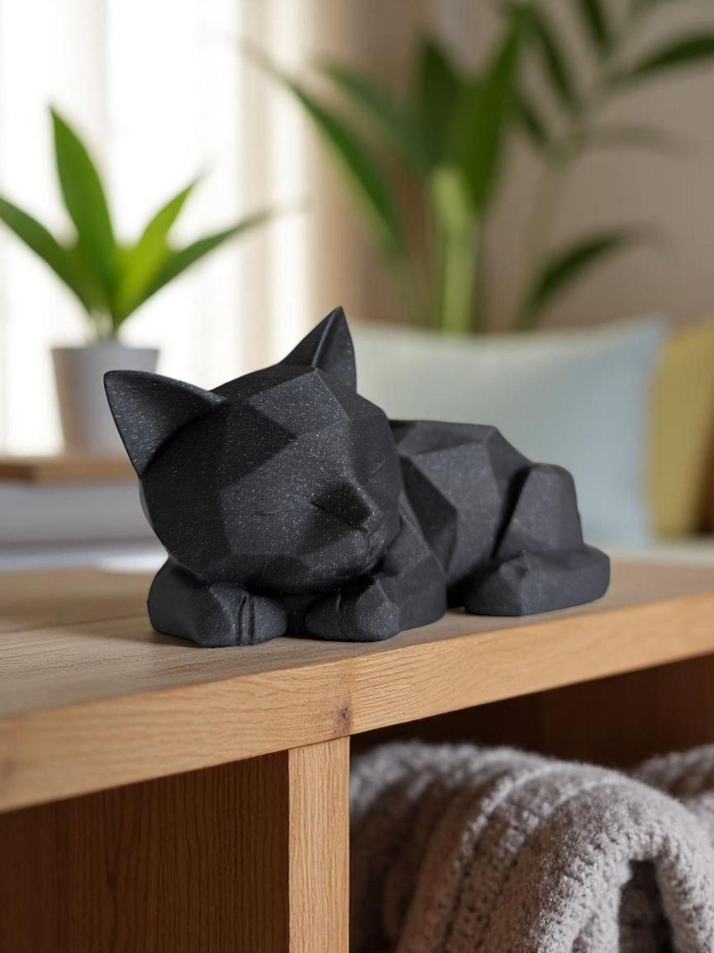 Cute low poly kitten figurine displayed on wooden shelf with plants