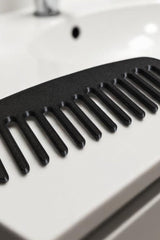 Detangle hair comb with alternating long and short staggered teeth, close-up view