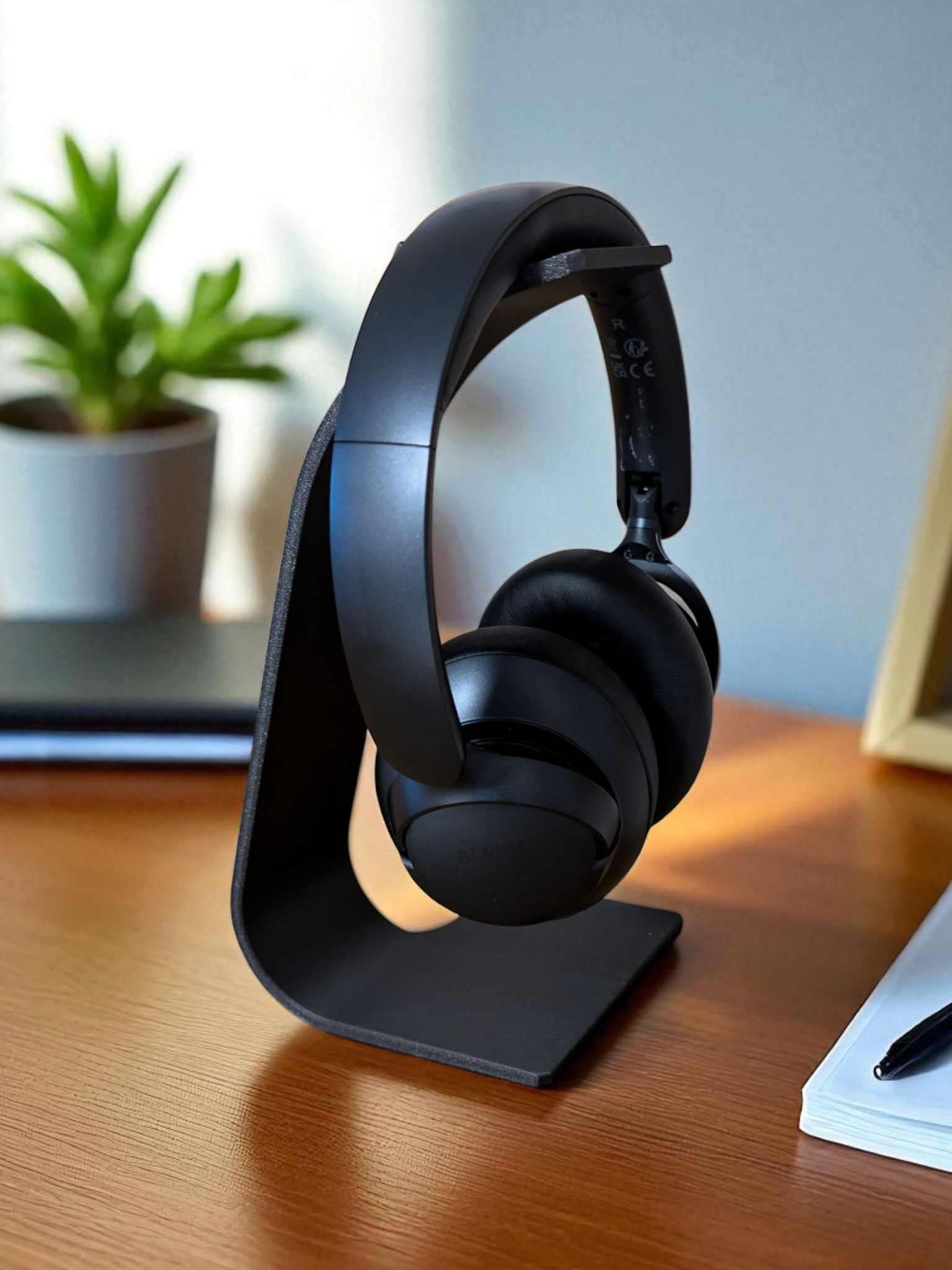 Minimalist headphone stand in a calm workspace with headphones resting on the curved support