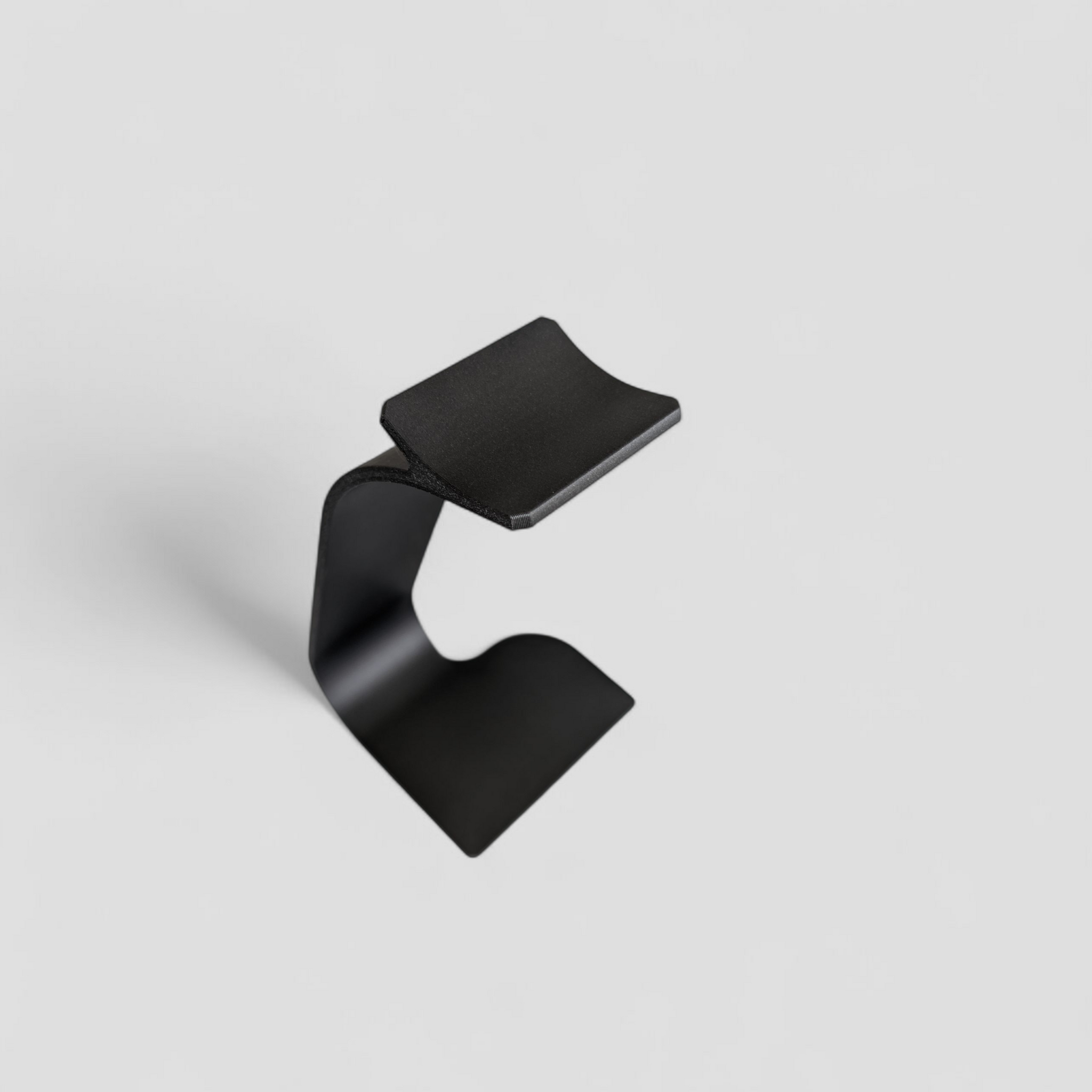 Swing headphone stand viewed from the side, showing curved cantilever arm and stable base