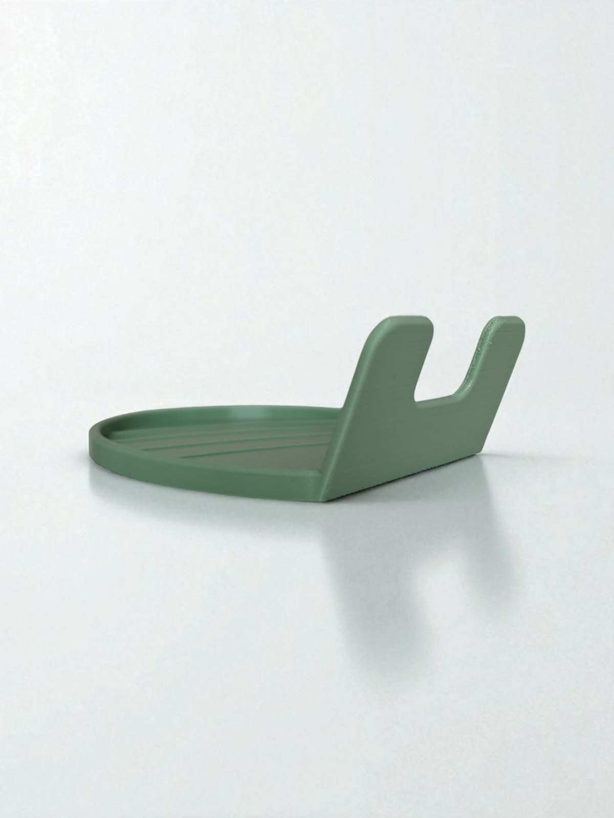 White spoon rest holding a wooden spoon, close-up view of the curved lip design