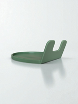 White spoon rest holding a wooden spoon, close-up view of the curved lip design