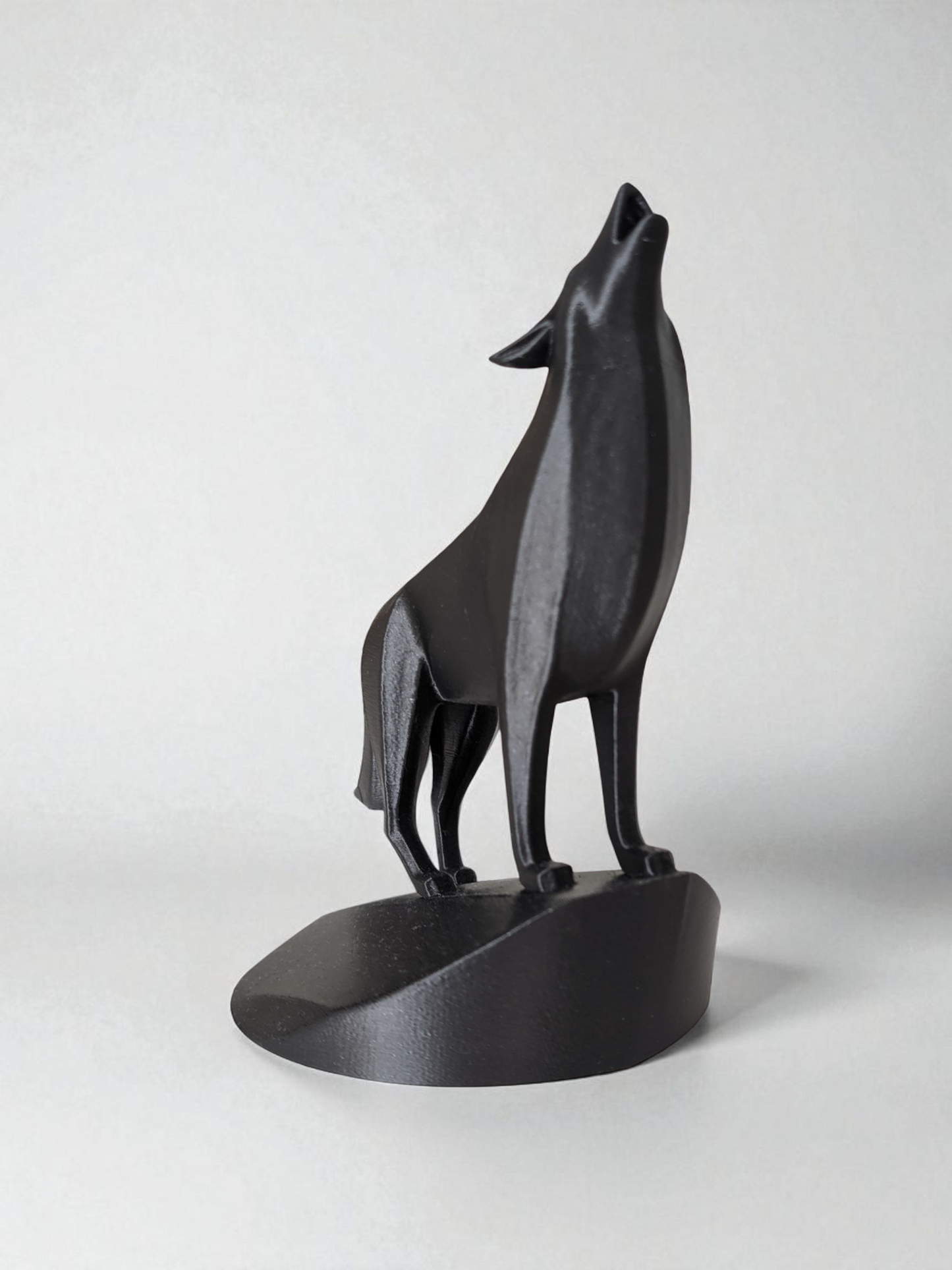 Close-up of minimalist wolf sculpture showing geometric planes and open mouth detail