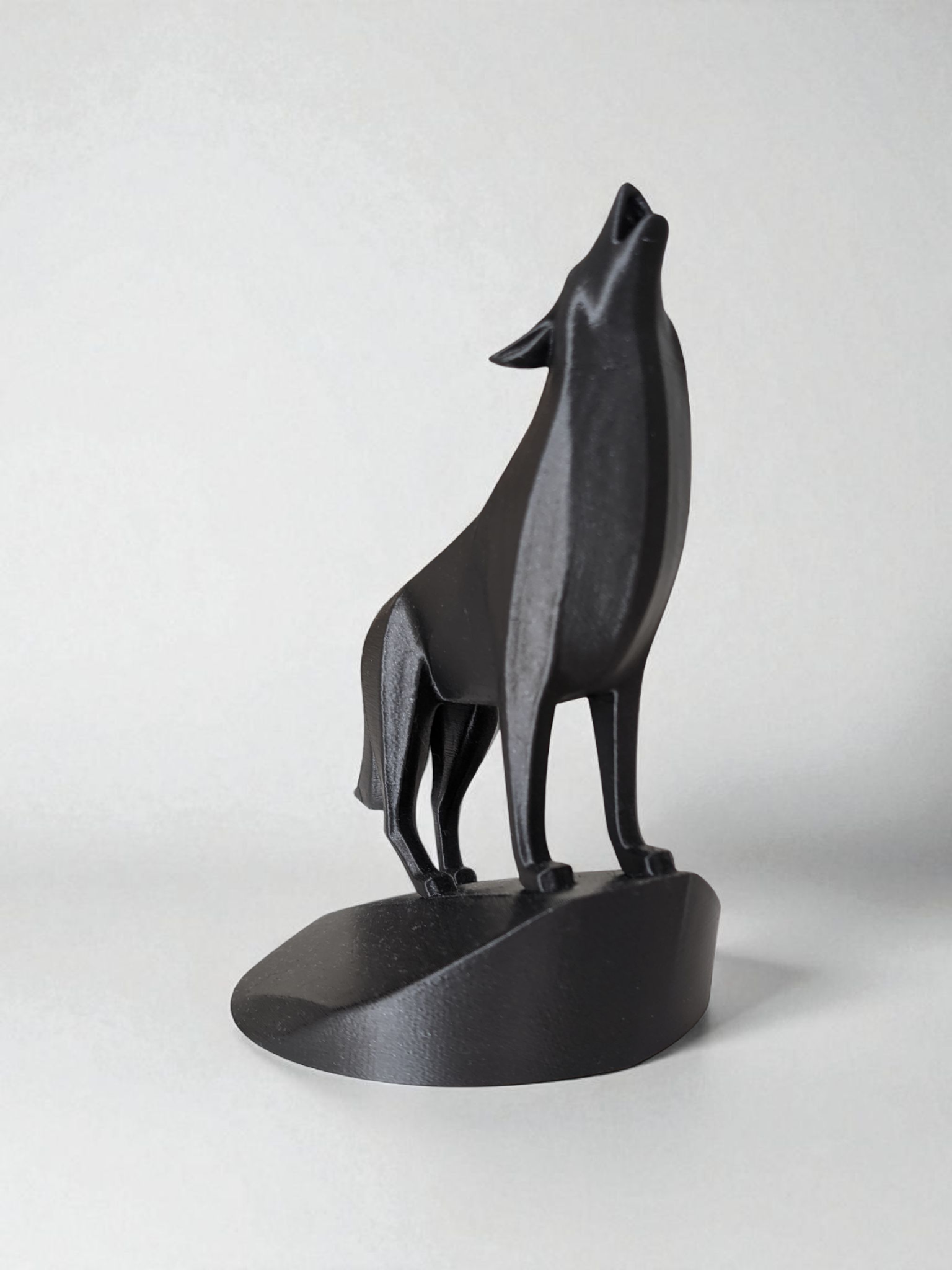 Close-up of minimalist wolf sculpture showing geometric planes and open mouth detail