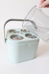 White freezable cooler cube on outdoor picnic table with drinks nearby