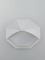 Close-up of geometric pyramid catchall tray showing faceted angles and octagonal base