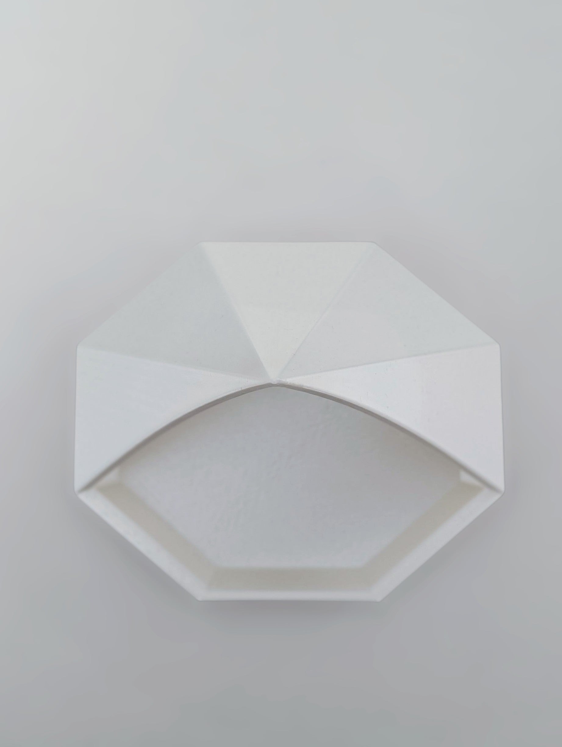 Close-up of geometric pyramid catchall tray showing faceted angles and octagonal base