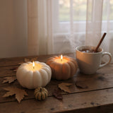 Terracotta pumpkin tealight holder glowing with LED light on wooden shelf