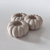 Close-up of ribbed pumpkin tealight holder showing texture and three candle recesses